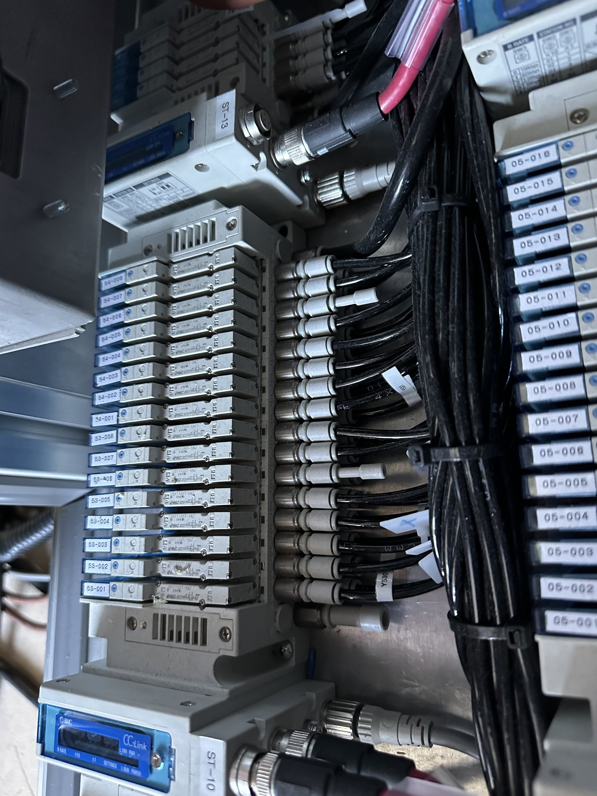 Pneumatic valve island inside a machine: every station labelled, tubing and sensor cables routed and tied
